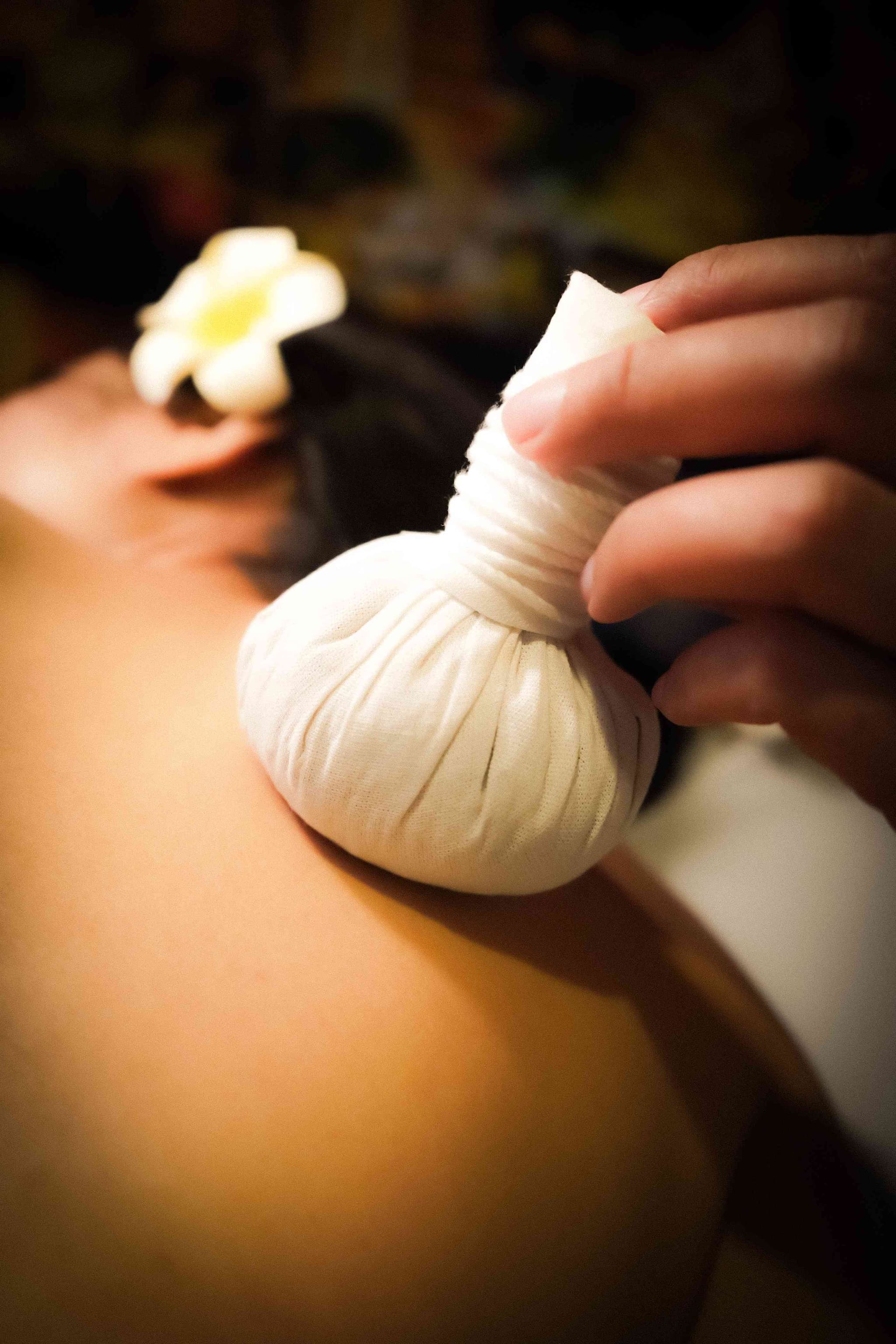Herbal compress therapy session at Bloom Thai Therapy in Arlington VA for summer athletic recovery and muscle relief